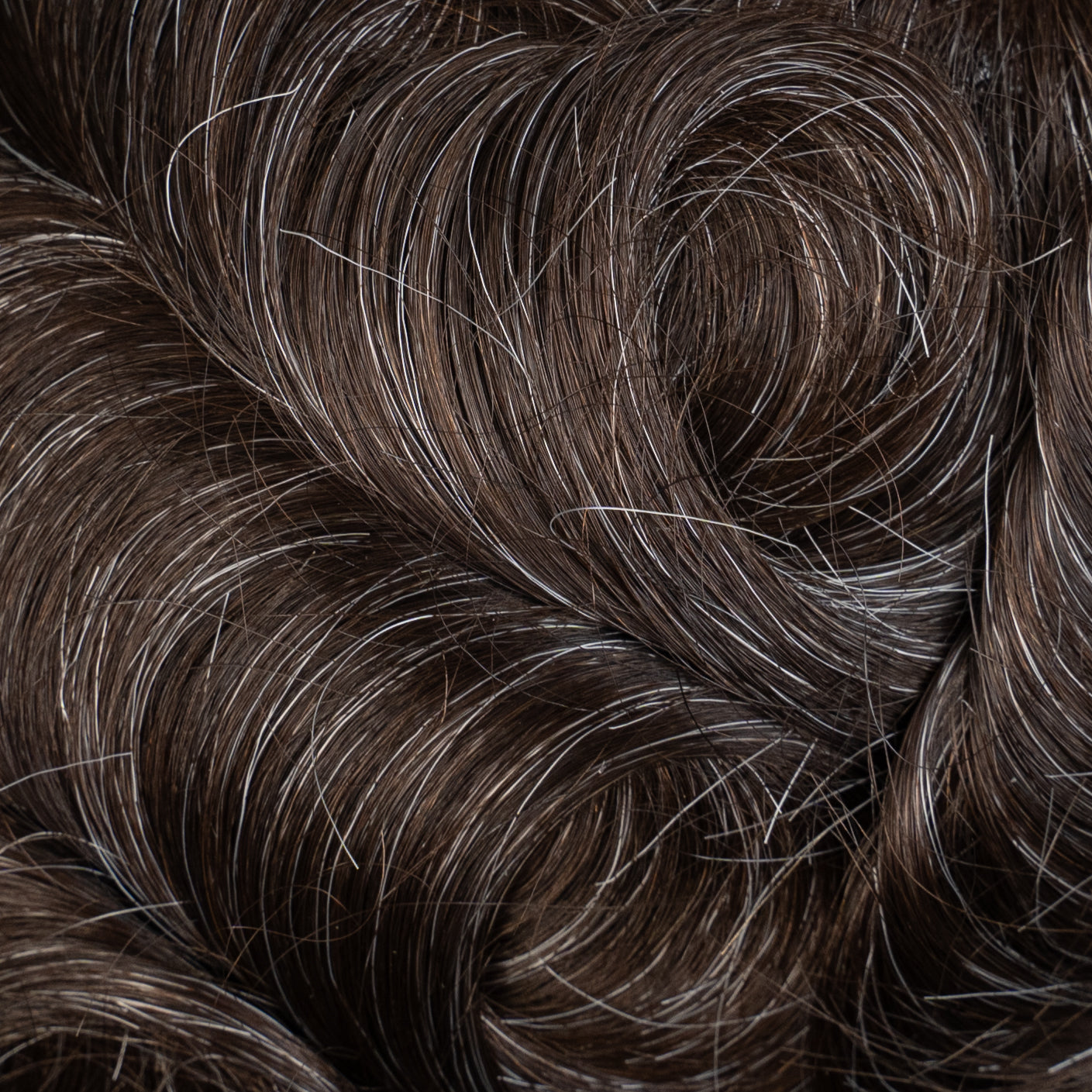 Close-up image of Poly Hair System in medium density, a durable and natural-looking hair replacement solution for men and women with thinning hair or hair loss